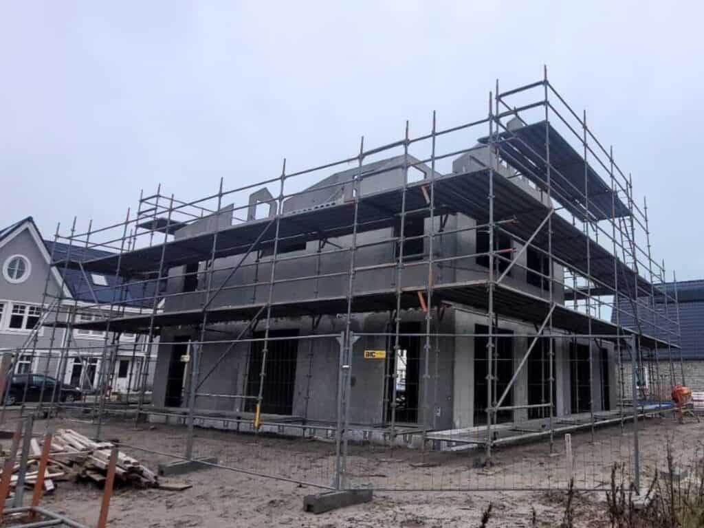 Betonconstructie met steiger voor nieuwbouw woning, bouwfase in progress Sicherheit.