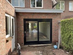 modern terrasdeur met zwart frame en grote glazen panelen, perfect voor tuintransformatie en woningverbetering.