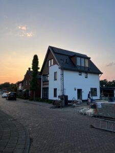 modern woning onder constructie met zonnepanelen op het dak en bouwactiviteiten in volle gang.